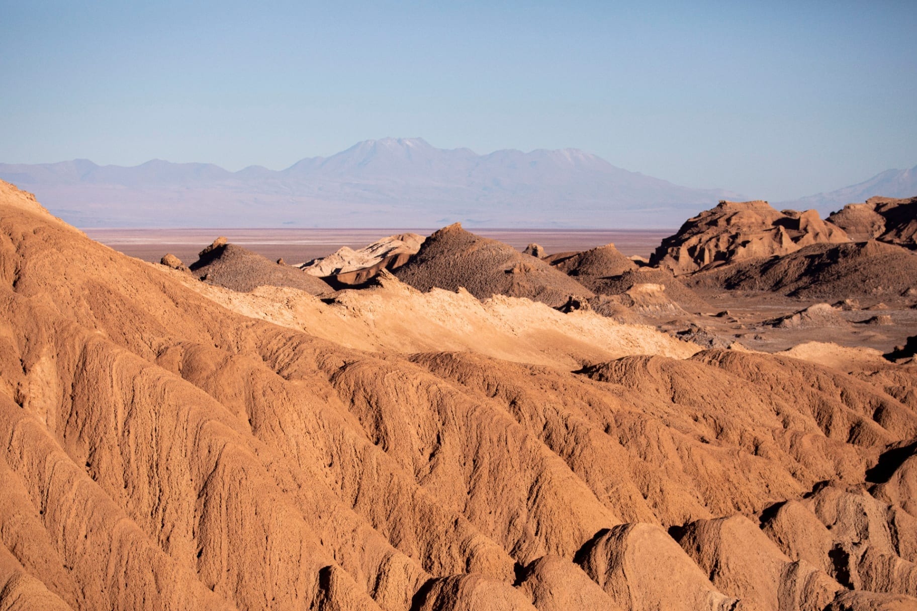 Texturas erodidas do Valle de la Luna com cordilheira ao fundo