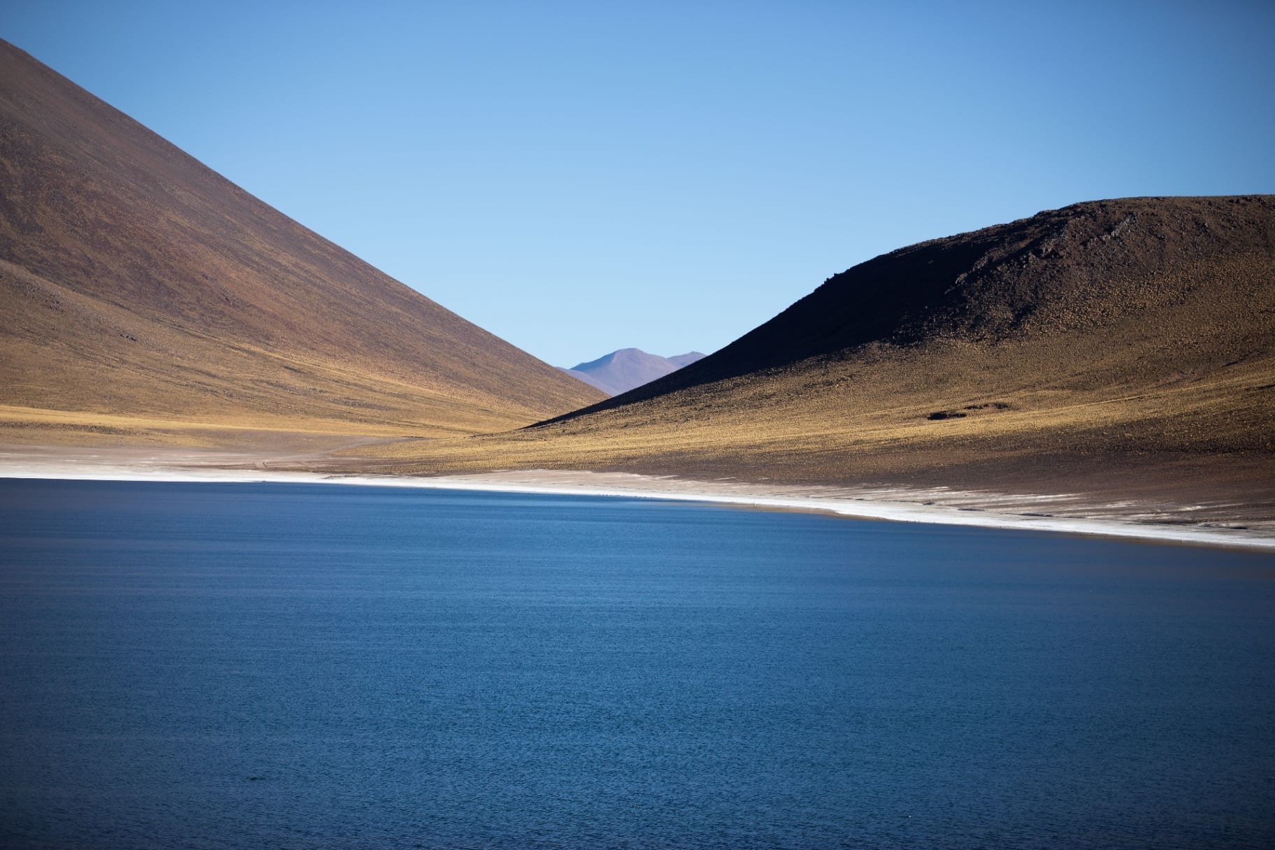 Lago azul encaixado entre duas encostas áridas